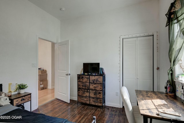 bedroom with a closet, baseboards, and wood finished floors