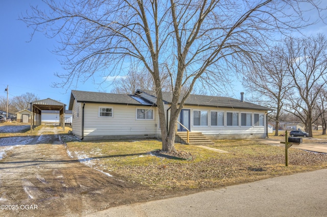 view of front of property with crawl space, a detached carport, an outbuilding, and dirt driveway