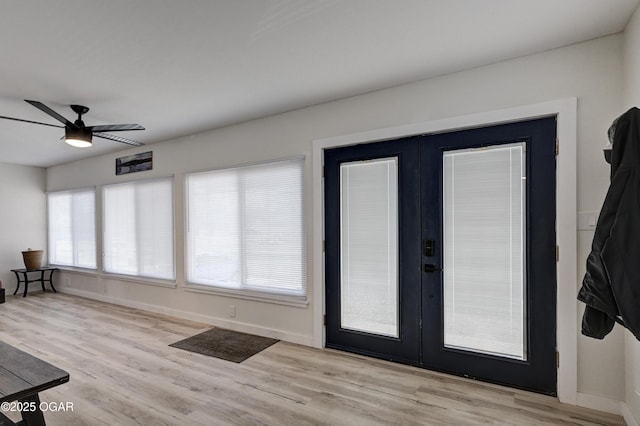 entrance foyer featuring light wood-style flooring, french doors, baseboards, and a healthy amount of sunlight