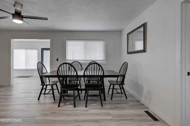 dining area featuring visible vents, light wood-style flooring, and baseboards