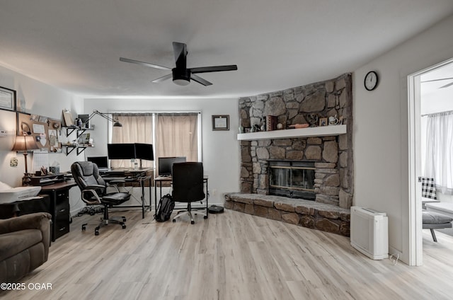 office space with ceiling fan, wood finished floors, and a fireplace