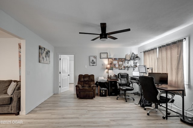 office space with light wood-type flooring, baseboards, and a ceiling fan