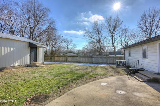 view of yard featuring a patio, fence, and central AC