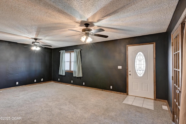 entryway with baseboards, carpet flooring, a textured ceiling, and a ceiling fan