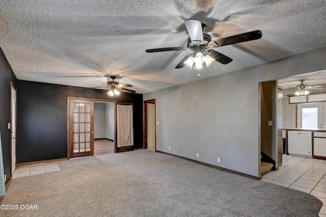 unfurnished room with light carpet, a textured ceiling, baseboards, and light tile patterned flooring