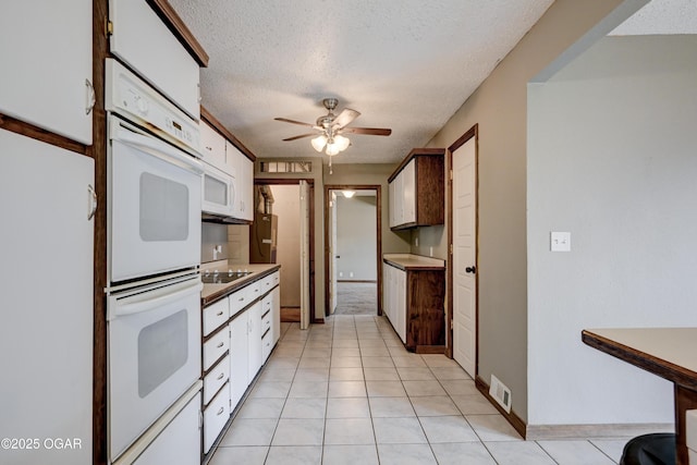 kitchen featuring white cabinetry, double oven, a textured ceiling, and black electric stovetop