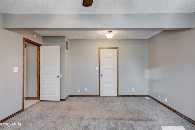 interior space with carpet flooring, a textured ceiling, and baseboards