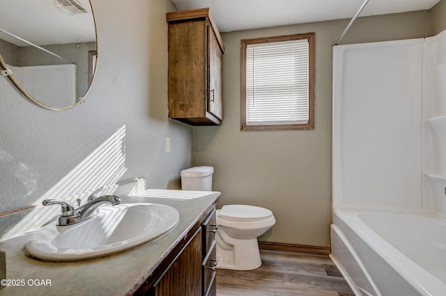 bathroom with visible vents, toilet, shower / bathtub combination, wood finished floors, and vanity