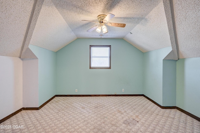 bonus room with baseboards, a textured ceiling, lofted ceiling, and a ceiling fan