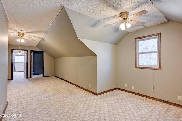 additional living space with a ceiling fan, baseboards, carpet floors, and a textured ceiling