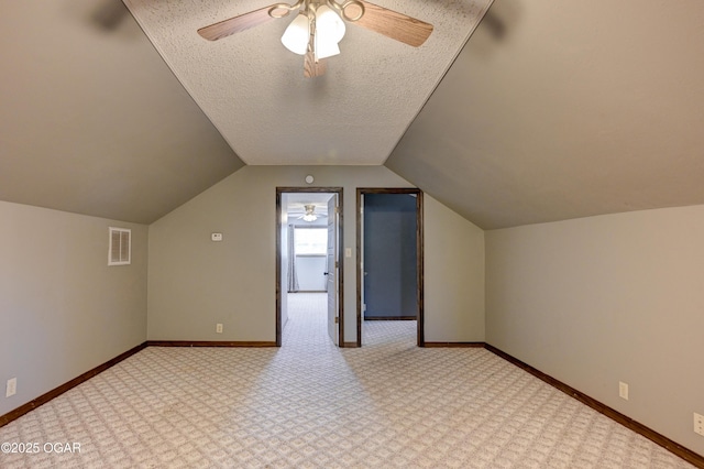 additional living space with baseboards, visible vents, and a textured ceiling