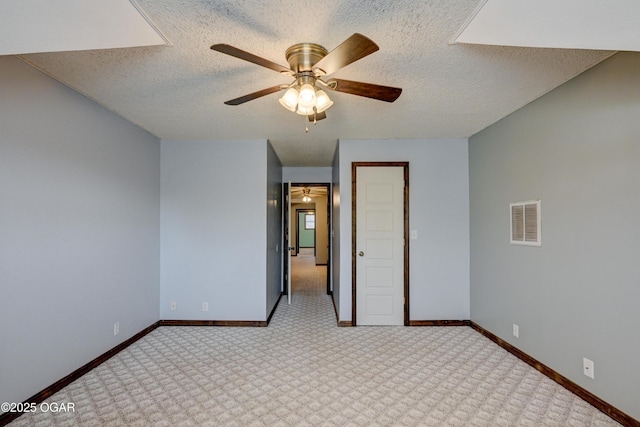 unfurnished bedroom featuring a textured ceiling, carpet, visible vents, and baseboards