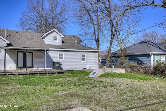 rear view of house with a lawn and a shingled roof