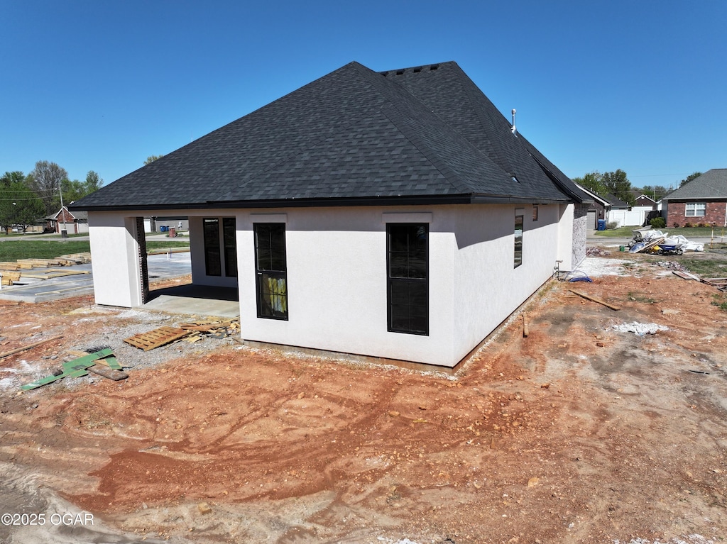 view of side of home with a shingled roof