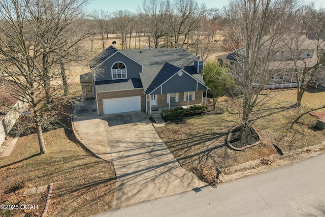 view of front of property with brick siding, a garage, and driveway