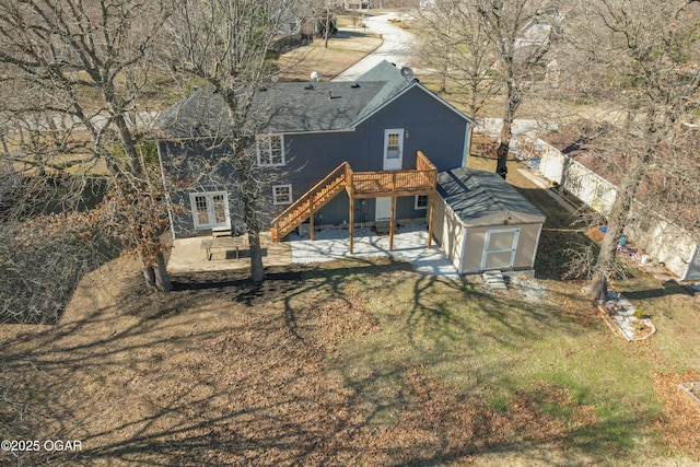 rear view of property with a wooden deck, stairs, roof with shingles, french doors, and a patio area