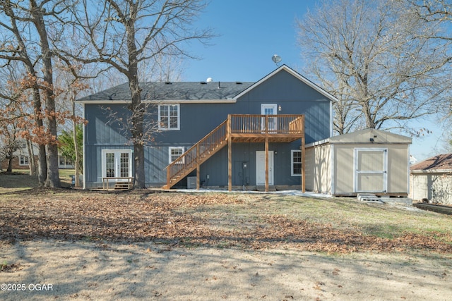 back of house featuring an outbuilding, stairway, a storage unit, french doors, and a deck