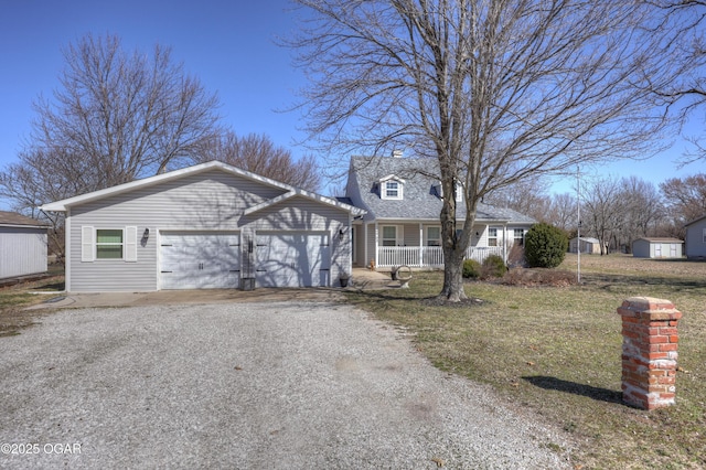 view of front of property featuring gravel driveway, an attached garage, and covered porch