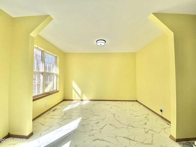 spare room with visible vents, marble finish floor, and baseboards