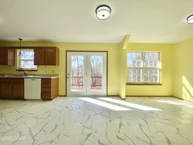 kitchen featuring marble finish floor, a sink, white dishwasher, light countertops, and baseboards