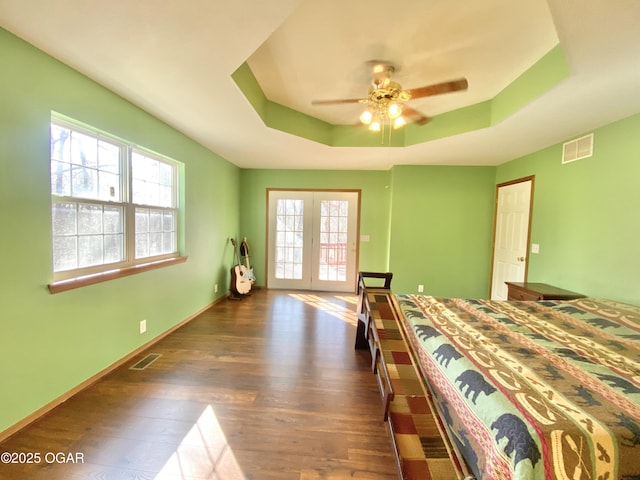 bedroom with visible vents, multiple windows, and a raised ceiling