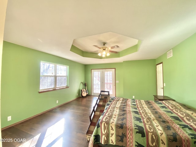 unfurnished bedroom featuring visible vents, baseboards, dark wood finished floors, french doors, and a raised ceiling