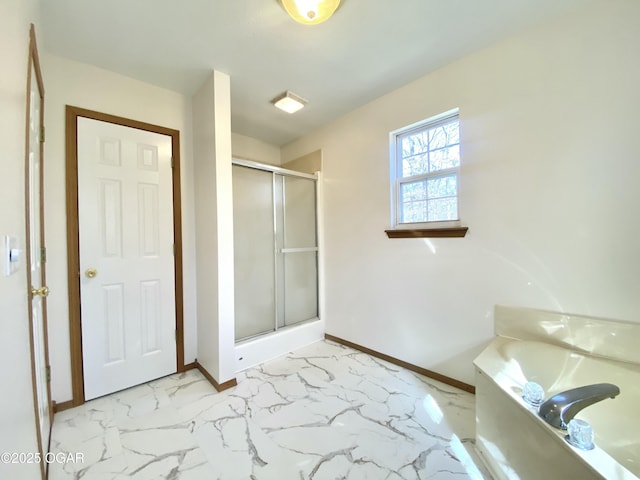 full bath with a shower stall, a garden tub, marble finish floor, and baseboards