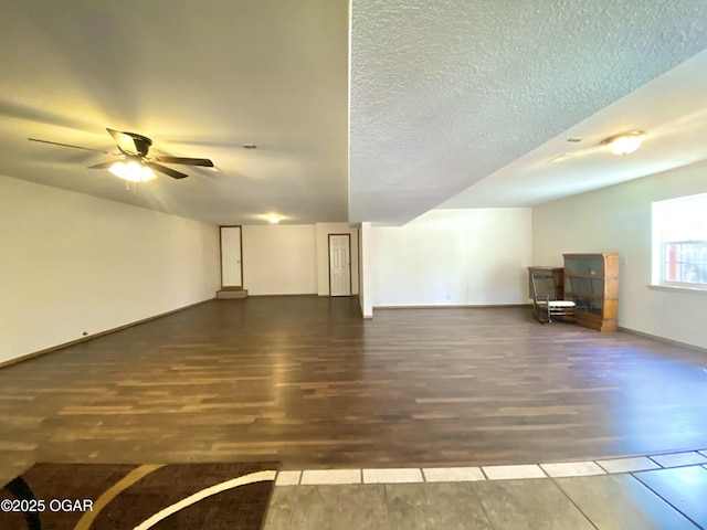 unfurnished living room with baseboards, a textured ceiling, wood finished floors, and a ceiling fan