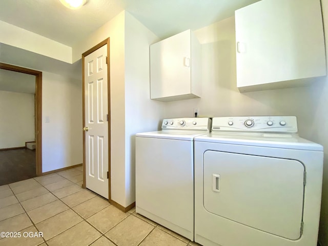 laundry room with light tile patterned floors, baseboards, cabinet space, and separate washer and dryer