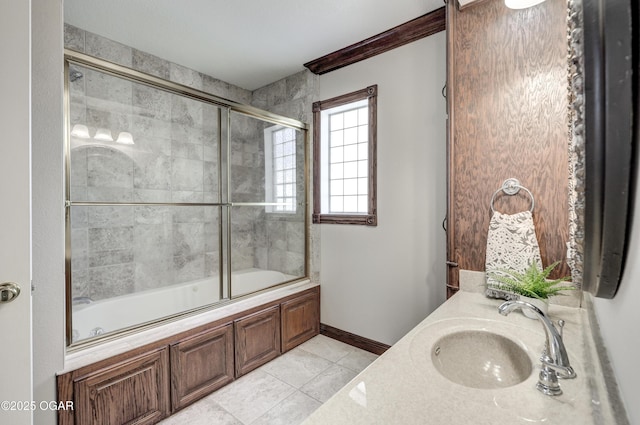 full bathroom featuring tile patterned floors, enclosed tub / shower combo, baseboards, and a sink