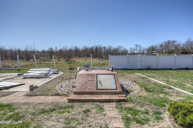 entry to storm shelter featuring a lawn and fence