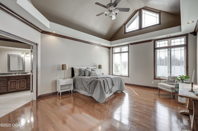 bedroom with light wood-style floors, baseboards, and high vaulted ceiling