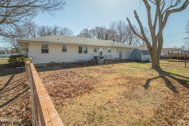 rear view of house with crawl space, a storage unit, cooling unit, and an outdoor structure