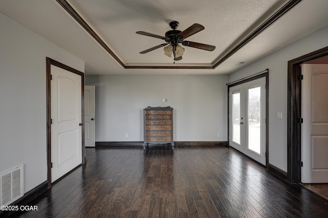 unfurnished room featuring hardwood / wood-style floors, a raised ceiling, and visible vents