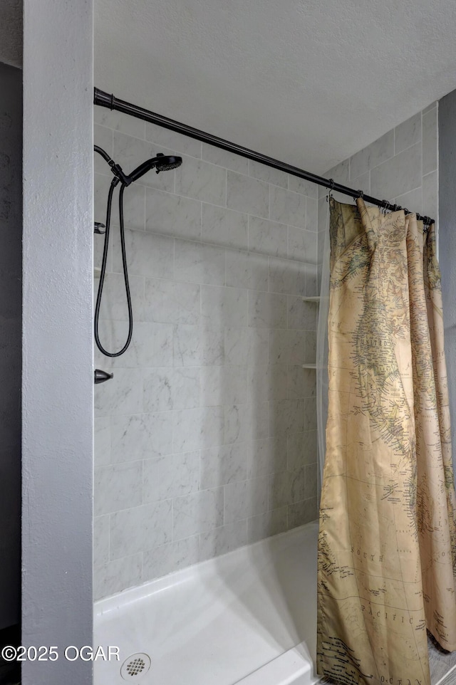 bathroom with a shower stall and a textured ceiling