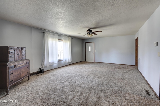 spare room with carpet flooring, visible vents, baseboards, and ceiling fan