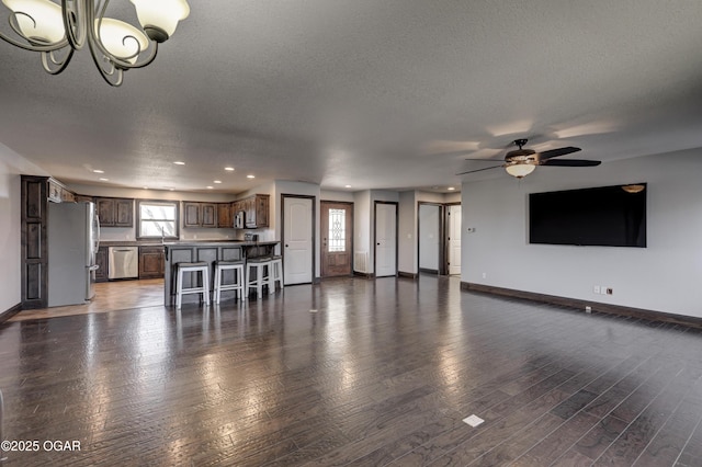 unfurnished living room with plenty of natural light, baseboards, and wood finished floors