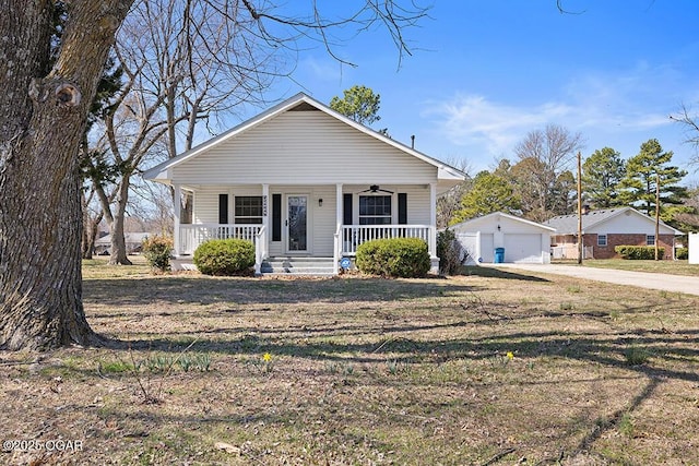 bungalow-style home featuring covered porch, ceiling fan, an outdoor structure, a front lawn, and a garage