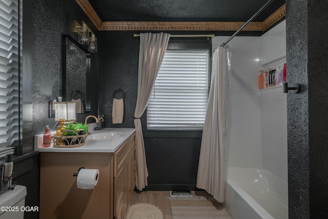 full bath with vanity, a textured wall, shower / bath combo, and a textured ceiling