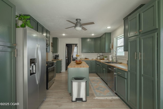 kitchen featuring a ceiling fan, butcher block countertops, green cabinets, and appliances with stainless steel finishes