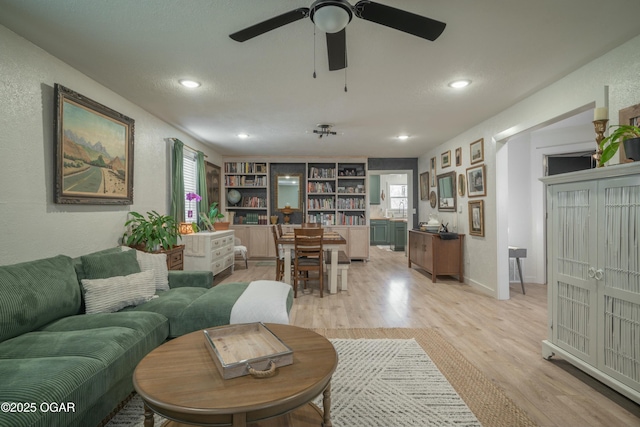 living area with recessed lighting, baseboards, ceiling fan, and light wood finished floors