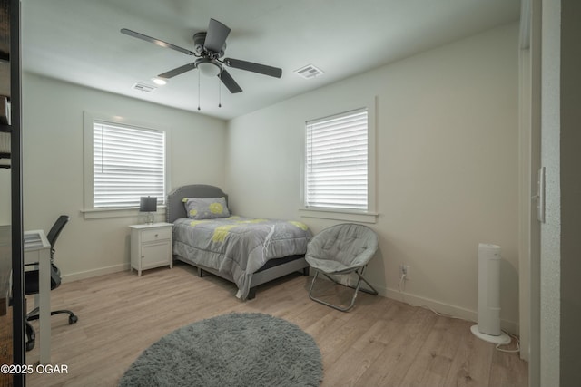 bedroom with baseboards, visible vents, and light wood finished floors