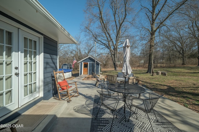 view of patio with an outdoor structure, french doors, and a shed