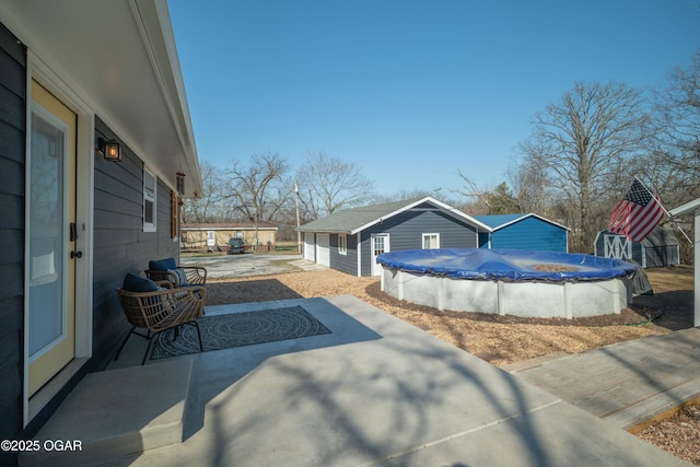 view of patio with a covered pool and an outdoor structure