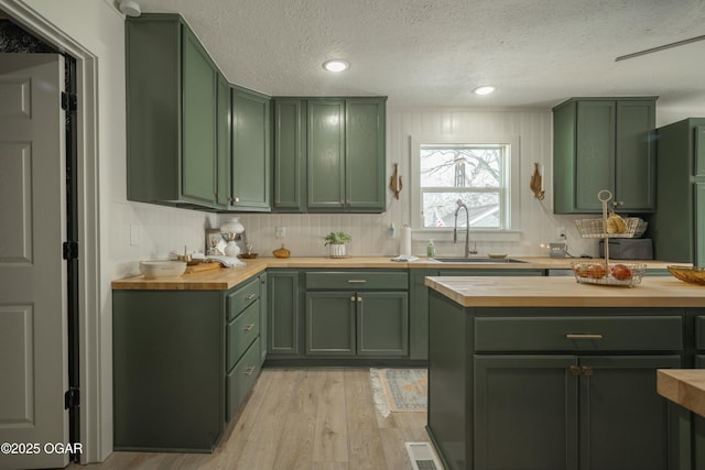 kitchen with butcher block countertops and green cabinets