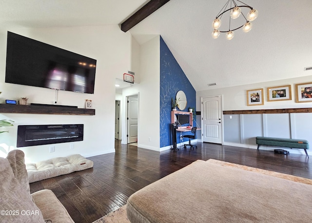 living area with baseboards, beamed ceiling, hardwood / wood-style flooring, a glass covered fireplace, and high vaulted ceiling