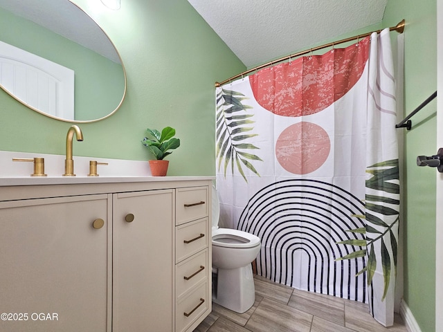 bathroom featuring wood tiled floor, toilet, a shower with shower curtain, vanity, and a textured ceiling