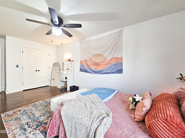 bedroom with a ceiling fan, wood finished floors, and a textured ceiling