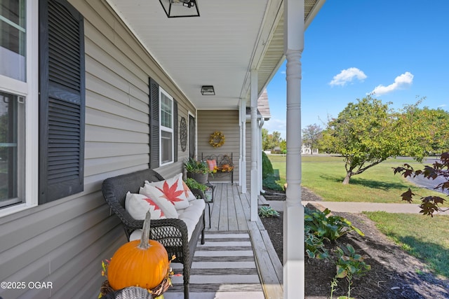 wooden deck with a yard and a porch