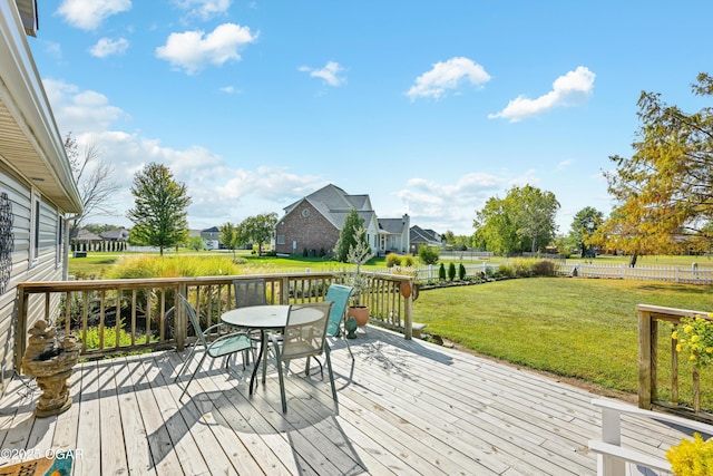 wooden deck featuring a residential view, a lawn, and outdoor dining space